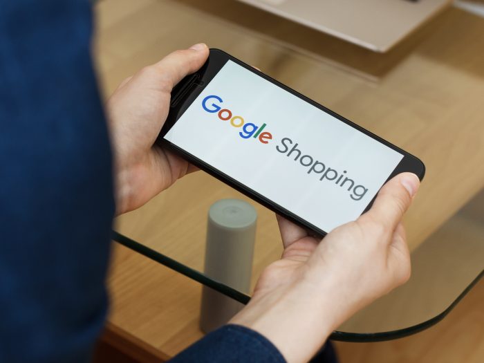 Hands holding smartphone using Google Shopping